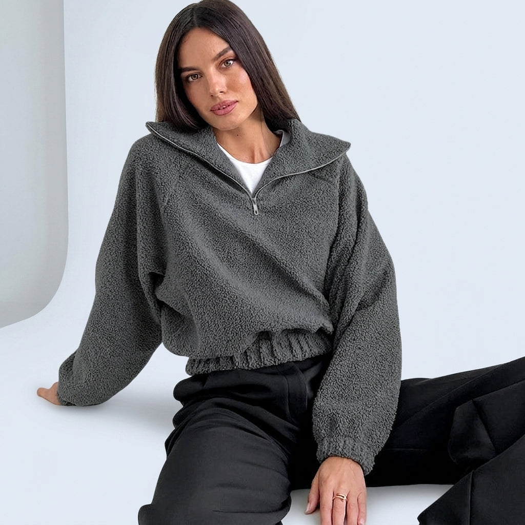 Modelo sentada con chaqueta teddy ROHPPER en gris